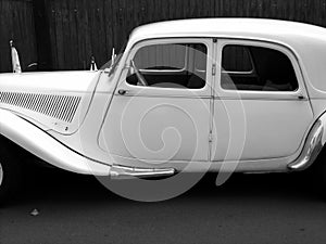 Grayscale shot of a white French classic limousine as a wedding car