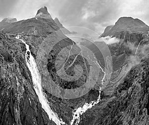 Grayscale. Summer Trollstigen serpentine mountain path road and Stigfossen waterfall view from The Trolls Path Viewpoint, Norway