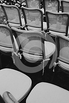 Grayscale vertical of wedding chairs on an outdoor hall