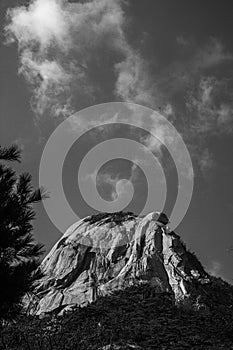 Grayscale view of inselberg against cloudy sky background