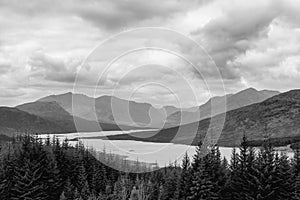 Grayscale view over Loch Loyne, showcasing rugged Scottish Highlands and textured skies