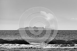 Grayscale view of the sea waves before the Whakaari Island