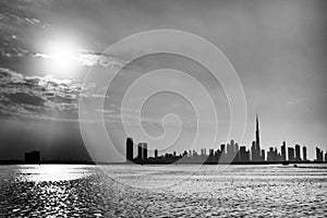 Grayscale view of the skyline of Dubai city from the sea at sunset, United Arab Emirates