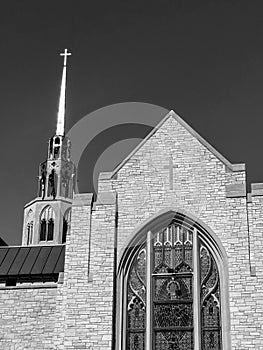 Grayscale view of unique church with tall steeple