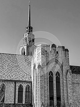 Grayscale view of unique church with tall steeple