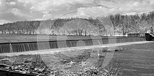 Grayscale of a water cascade in a park on a sunny day