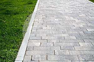 Graystone sidewalk with grass. background, nature