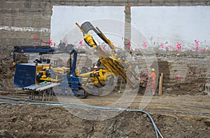 Graz/Austria - October 09, 2019: workers on construction site and a heavy duty machinery used for drilling holes in the ground