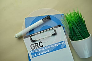 GRC - Governance, Risk Management, and Compliance write on a paperwork isolated on office desk photo