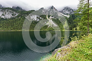 Great azure alpine lake Vorderer Gosausee. Picturesque and gorgeous rain clouds