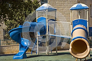 Great blue slide in a children's playground, modern example of how kids can play safe and have lot fun.