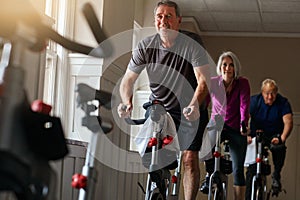 Great bodies are created through hard work not age. a group of seniors having a spinning class at the gym.