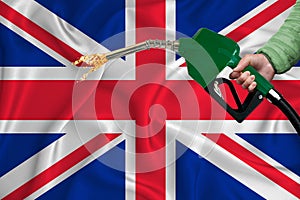 GREAT BRITAIN flag Close-up shot on waving background texture with Fuel pump nozzle in hand. The concept of design solutions. 3d