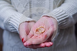 Great concept of divorce woman hand with two gold wedding rings in hand