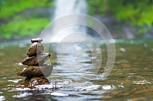 Great concept of spiruality, tranquility and meditation, land art with stones in waterfall