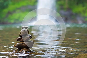 Great concept of spiruality, tranquility and meditation, land art with stones in waterfall