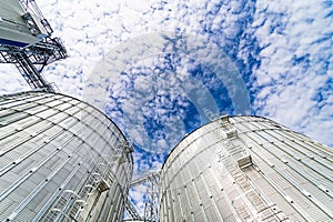 Great cylindric warehouse with blue sky. Big metallic industial construction. Steel store.