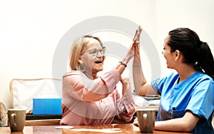 Great game. a senior woman playing cards with her caregiver.