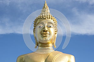 Great Golden Buddha statue in the temple with blue sky and white cloud