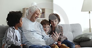 Great-grandfather and grandsons watching online content using smartphone