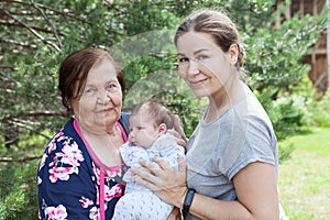 Great grandmother with her granddaughter and great-granddaughter, three people portrait at summer season, together