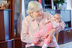 Great grandmother holding newborn baby grandchild on arm