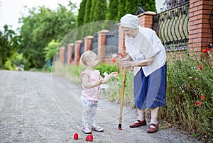 Great grandmother and toddler girl picking flowers outdoors