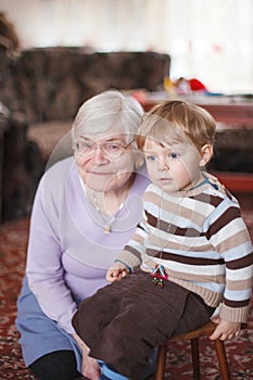 Great-grandmother with toddler and her grandson, indoor