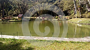 GREAT GREEN LAKE LOCATED AT THE ATLANTIC MATA FENCED WITH TREES AND PLANTS WITH PONTE CERCA AND CHILDREN`S CASINHAS, PETROPOLIS RI