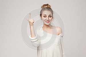 Great idea! Young adult woman finger up. Idea sign
