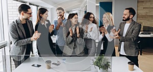 Great job! Successful business team is clapping their hands in modern workstation, celebrating the performance of new product