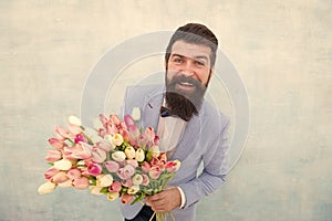 In great mood. bride groom at wedding party. bearded man in bow tie with tulip flowers. love date with flowers. Happy