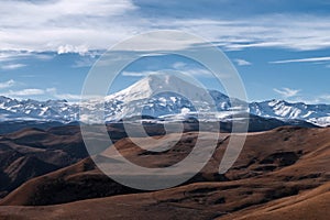 Great nature mountain range. Amazing perspective of  Elbrus with autumn fields, blue sky background