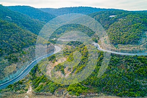 Great Ocean Road bends through forested hills.