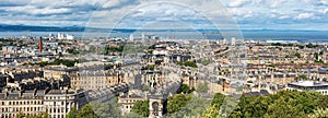 Great panorama of the city of Edinburgh on the seashore with buildings and boats in the harbor, Scotland