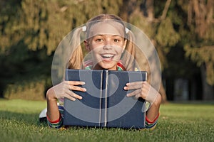 Great place to read. Happy small child read library book outdoor. Adorable little girl learning to read at primary