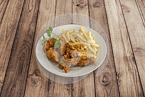 Great plate of crispy Kentucky-style chicken with a portion of French fries and a sprig of fresh parsley