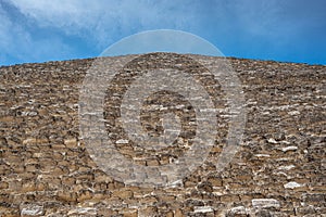 Great Pyramid of Giza. view of the great pyramid of Cheops from the foot. pyramid face wall, ancient stone blocks, blue sky with