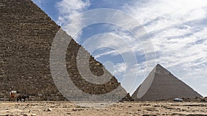 The Great Pyramids of Giza: Cheops and Chephren against a background of blue sky and clouds