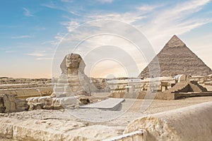 Great Sphinx against the background of the pyramids of the pharaohs Cheops, Khafren, and Mikerin in Giza