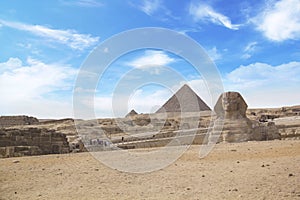 Great Sphinx against the background of the pyramids of the pharaohs Cheops, Khafren, and Mikerin in Giza