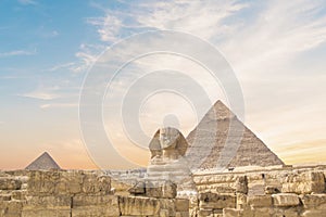 Great Sphinx against the background of the pyramids of the pharaohs Cheops, Khafren, and Mikerin in Giza