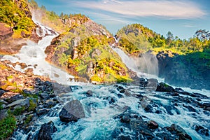 Great sunny view of Latefoss waterfall, located in the municipality of Odda in Hordaland County. Amazing summer scene in Norway.