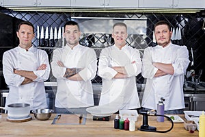 Great team of cooks standing in the middle of a kitchen