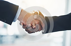 Great things will come from this merger. Closeup shot of two businessmen shaking hands in an office.