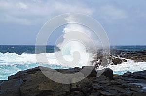 Great undertow on a rock in a rocky coast with blue sky