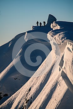 great view of beautiful relief snow-covered mountain slope and freeriding skiers on it