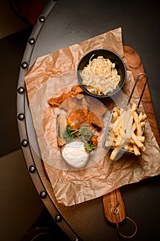 great view of french fries and bowl of sauerkraut and delicious batter fried pork ears on the table. Top view.