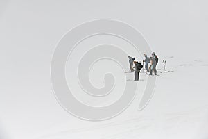 great view on group of ski tourists on backdrop of white winter snowy mountains. Ski touring concept