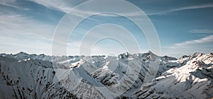 Great view of the massive snowy mountains. Amazing winter rocks above the cloud